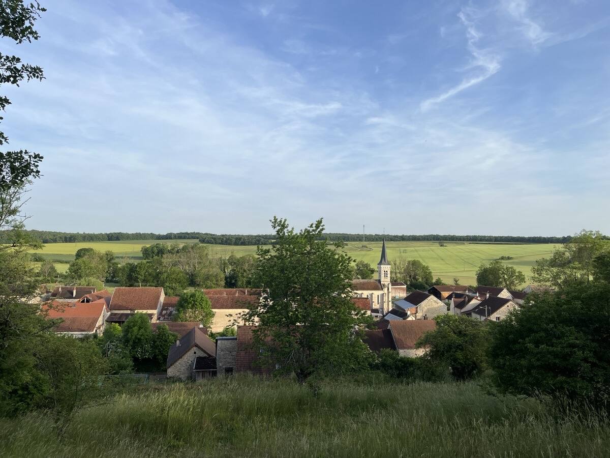 Vue panoramique du village de Baon depuis les hauteurs, clocher et toits de tuiles entourés de champs